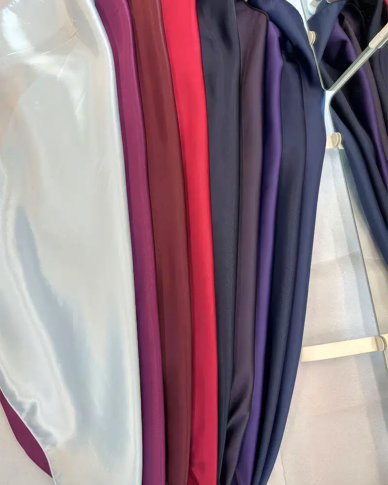 A row of drapes in various colors hanging neatly on a rack, showcasing a range of styles and fabrics.